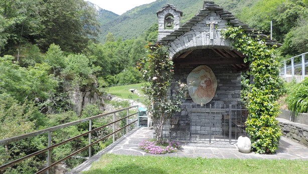 A stone chapel with a bell tower, surrounded by lush greenery and a river. - Holiday house with big garden, Resa Valley, Locarno (Brione sopra Minusio)