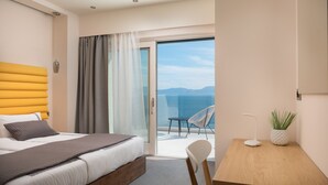 A modern hotel room with a bed, a desk, a chair, and a view of the sea. - LUXURY VILLA BLUE MOON (PODACA)