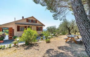 Experience a tranquil retreat in a traditional house surrounded by a well-maintained garden and olive trees.