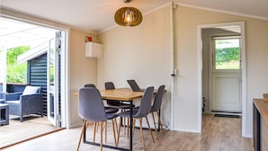 A dining area with a wooden table and six chairs, a pendant light, and a view of the outdoors. - 2 bedroom amazing home in Kirke Såby (Kirke Såby)