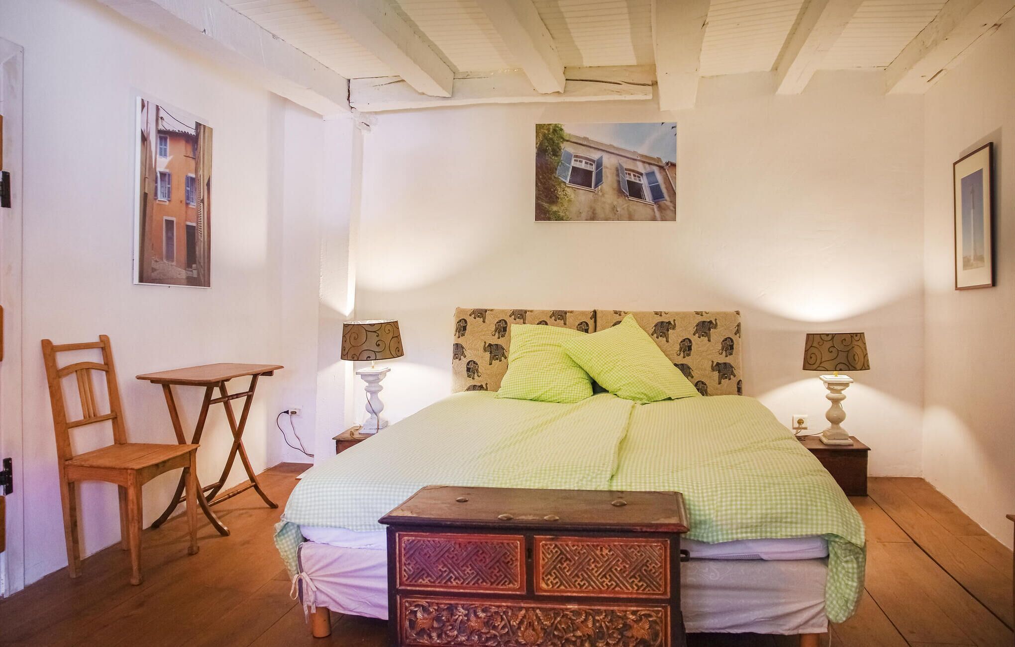 Une chambre à coucher comprenant un lit, deux tables de chevet, une chaise et une petite table.