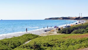 Une plage avec des gens, des bateaux et des tentes.