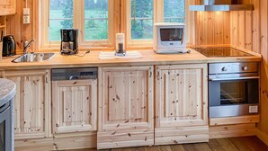 A kitchen with wooden cabinets, a built-in dishwasher, a stove, and a microwave. - Beautiful home in Sjusjoen (Sjusjøen)