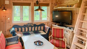 A cozy cabin interior with a wooden bench, a dining table, and a TV. - Beautiful home in Sjusjoen (Sjusjøen)