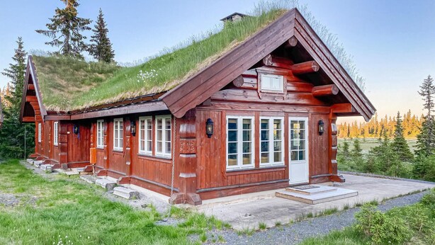 A wooden cabin with a grass roof, large windows, and a stone foundation. - Beautiful home in Sjusjoen (Sjusjøen)