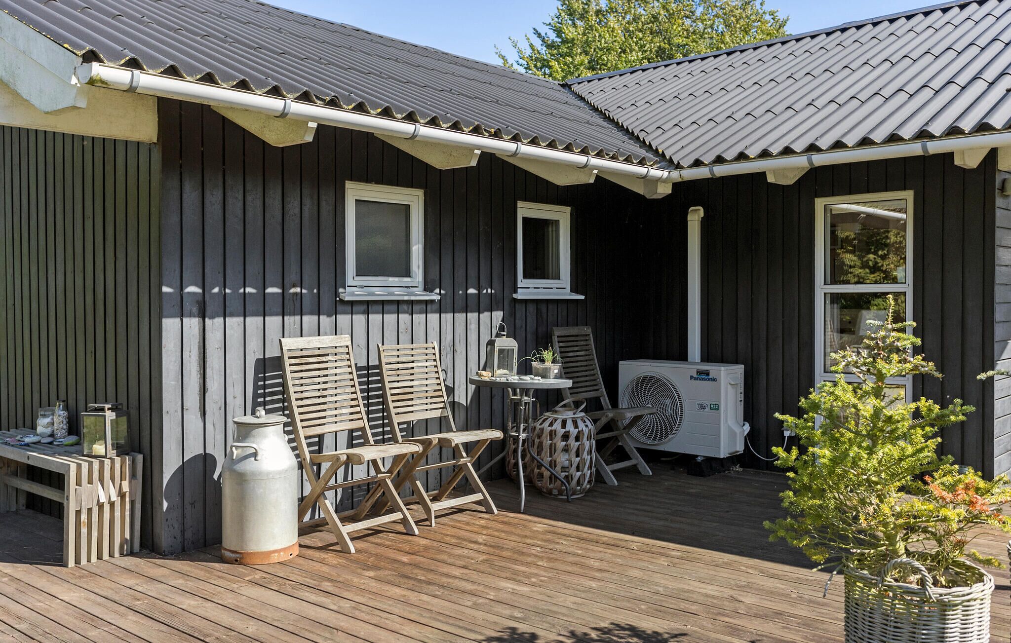 A wooden deck with outdoor furniture, a table, and a portable heater.