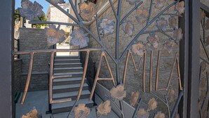 A staircase with a metal railing featuring leaf designs, leading to a stone building. - Stunning home in Klek (Klek)