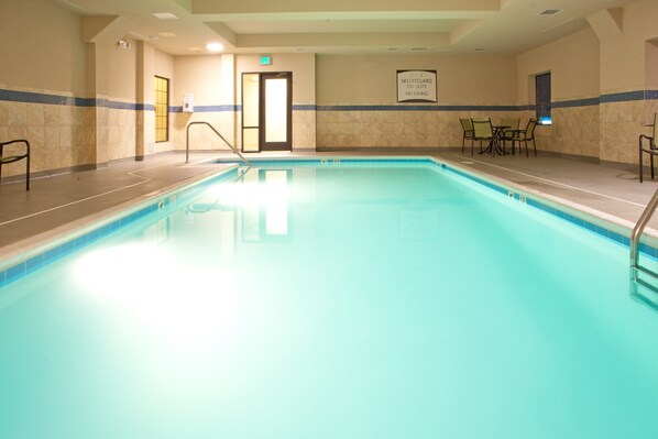 A swimming pool with a tiled border, a lifeguard station, and a sign indicating no lifeguard on duty. - King Suite | Shared Indoor Pool + Free Breakfast (Stafford)