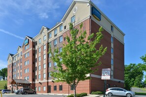 A multi-story hotel with a brick facade, a covered entrance, and a sign indicating a fire lane. - Studio Suite Great for Business Travelers | Shared Indoor Pool + 24h Business Center (Stafford)