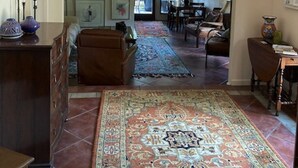 A spacious living area with a high ceiling, a large rug, and a staircase leading to another level. - Beautiful Mountain Vacation Rental (Pipe Creek)