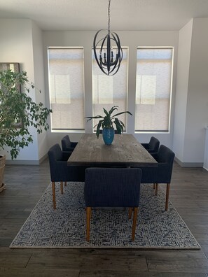 Enjoy meals in this dining room with a large window offering a view, a wooden table, and six comfortable chairs.