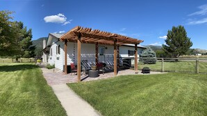 A house with a covered patio area, a pathway leading to the entrance, and a fenced yard. - Ranch-style home with horse property and fenced yard (Frenchtown)