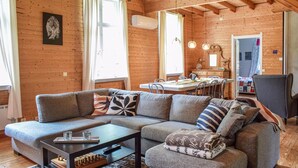 Ein gemütliches Blockhaus-Interieur mit einer Couch, einem Esstisch und einer Küchenzeile.