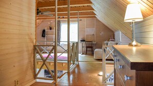Ein Zimmer mit Holzboden, einem Bett, einem Schreibtisch und einem Stuhl.