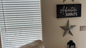 A room with a leather sofa, a small wooden side table, and decorative stars on the wall.