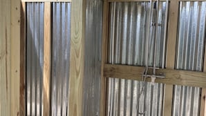 A wooden deck with a metal fence, a ceiling fan, and a showerhead. - Beautiful Broadkill Beach home with a short walk to the beach. (Milton)