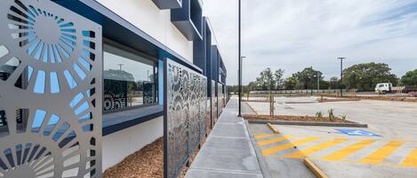 A modern building with a unique facade featuring geometric cut-out patterns.