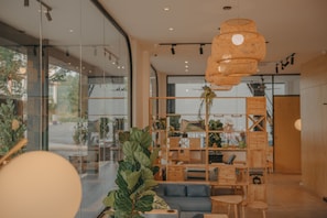 A modern interior with glass walls, a wooden shelving unit, and a hanging light fixture.