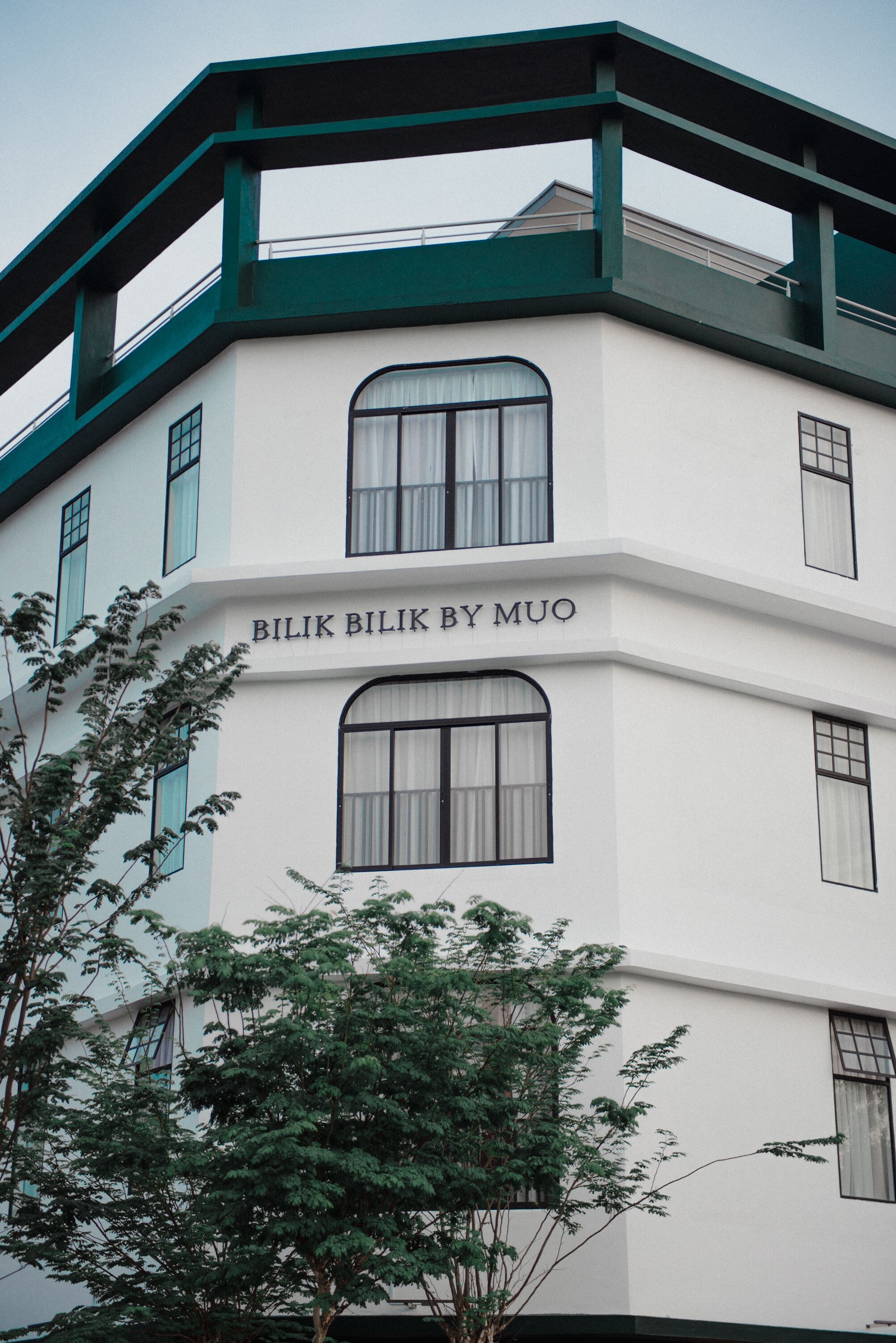 Un edificio con el nombre "Bilik Bilik By Muq" en la fachada.