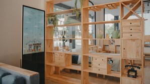 Un intérieur moderne avec des étagères en bois, une grande carte encadrée et un téléphone d’époque.