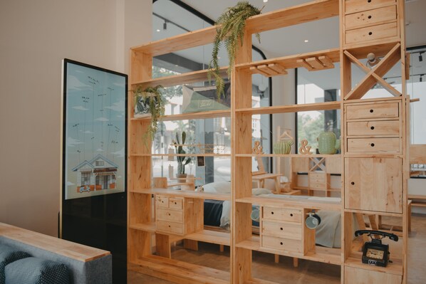 A modern interior with wooden shelving units, a large framed map, and a vintage telephone.