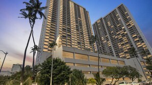A high-rise building with a modern architectural design, featuring a grid of windows and a flat facade. - Deluxe Ocean View Condo on 31st Floor - Free Parking & Wifi! (Honolulu)