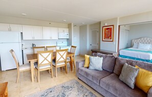 A compact living space with a kitchenette, dining area, and a bedroom.