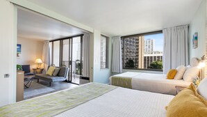 A hotel room with two beds, a sofa, a desk, and a balcony with a city view. - Light & Airy 8th Floor Ocean View Condo with Lanai and FREE Parking! (Honolulu)