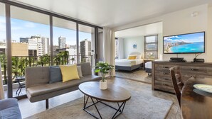 A modern living room with a sofa, coffee table, and TV. - Light & Airy 8th Floor Ocean View Condo with Lanai and FREE Parking! (Honolulu)