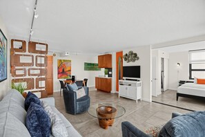 A modern living room with a sofa, a coffee table, and a TV.