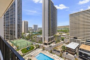 Un ensemble d’immeubles de grande hauteur comprenant un court de tennis, une piscine et un espace de détente.