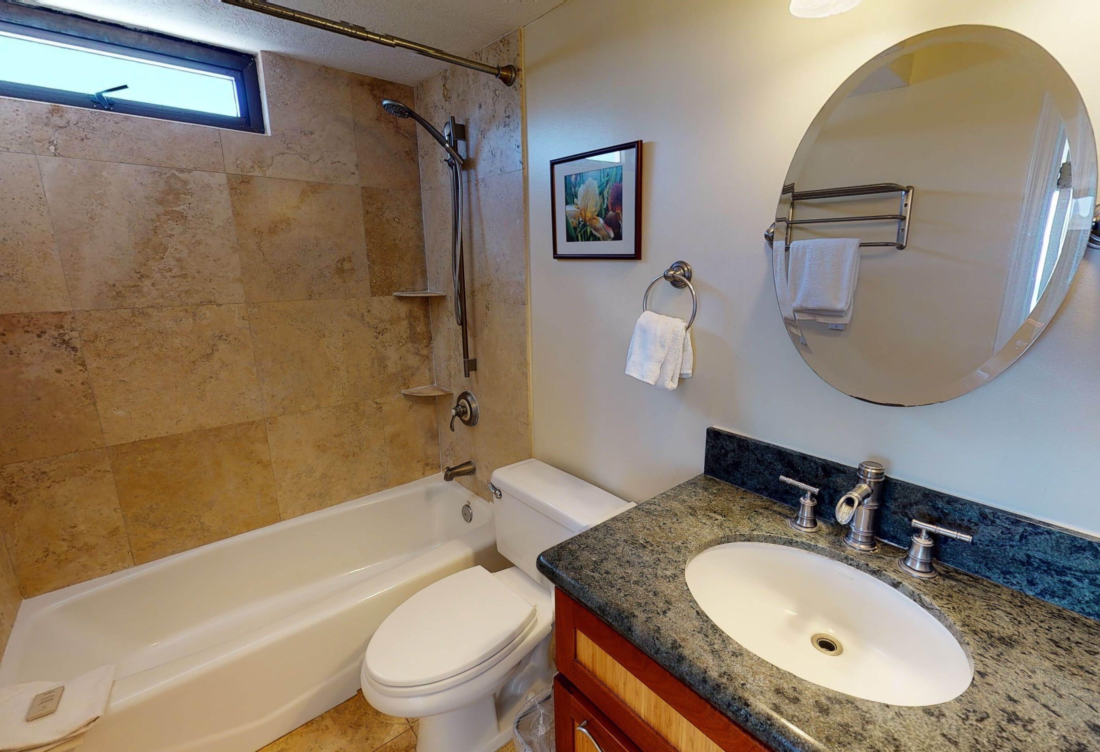 A bathroom with a bathtub, toilet, sink, and a large mirror.