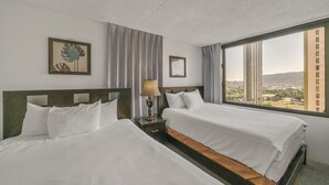 A hotel room with two beds, a nightstand with a lamp, a framed picture, and a view of a cityscape through a large window. - Excellent Diamond Head View Condo - Remodeled, Free Parking! (Honolulu)