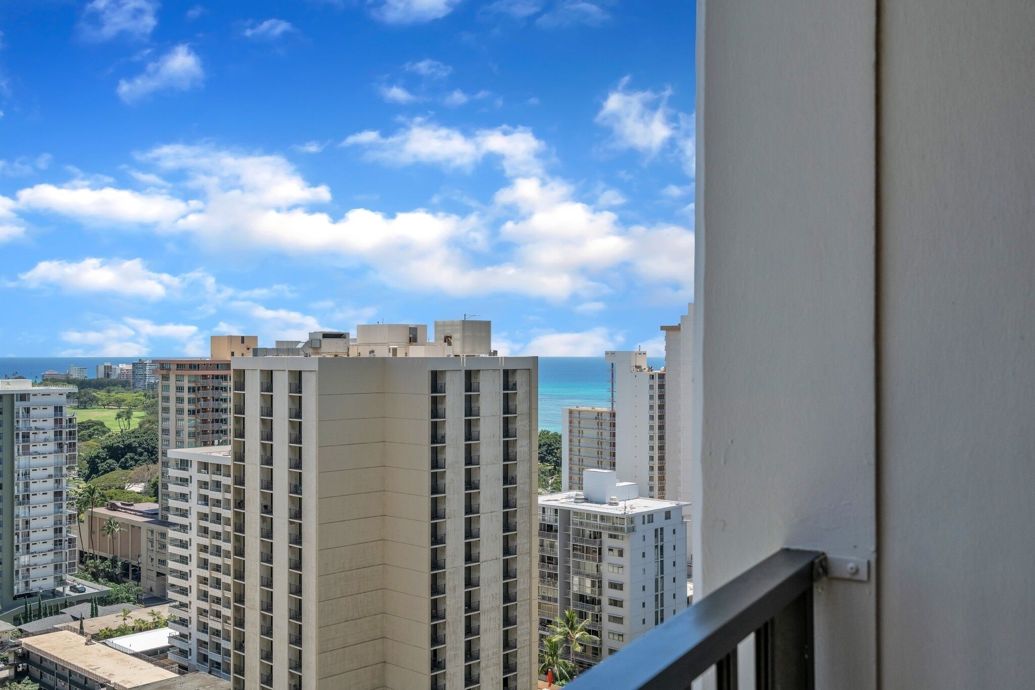 A high-rise building with a view of the ocean and other buildings.