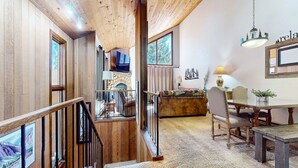 A wooden interior with a staircase, a dining area, and a fireplace. - Woodlands 25 Updated and Spacious, Quiet with Forest Setting Views townhouse by RedAwning (Mammoth Lakes)