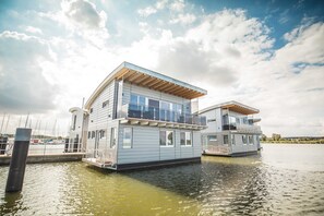 A floating houseboat with a balcony and a dock. - 07. Houseboats (105 m²) Poseidon - Houseboat No. 10 with a fireplace and (Kröslin)