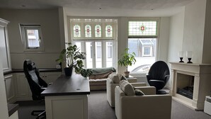 Una sala moderna con sofá, sillones, una mesa de centro y chimenea.