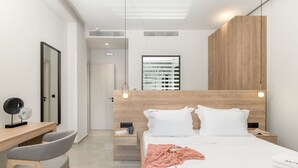 Ein modernes Hotelzimmer mit einem Holzkopfteil, einem Schreibtisch mit Stuhl, einem Nachttisch und einem großen Spiegel.