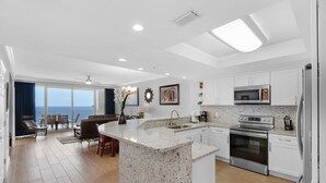 A modern kitchen with a central island, stainless steel appliances, and a view to the outside. - 🏖️XL Balcony, Great Views-3BR Boardwalk1801🏖️ (Panama City Beach)