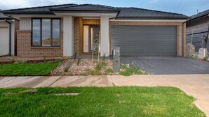 A modern single-story house with a garage, a front door, and a mailbox. - Resortstyle 4BR House With Parking@werribee (Werribee)