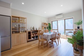 A modern kitchen with wooden cabinets and a dining area with a round table and chairs.