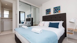 A modern hotel room with a large bed, a wardrobe, a mirror, and artwork on the wall. - The Lively City 2bed 2 Bath APT @footscray (Footscray)