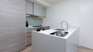 A modern kitchen with a central island, a built-in oven, and a stainless steel sink. - The Lively City 2bed 2 Bath APT @footscray (Footscray)