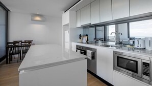 A modern kitchen with a central island, stainless steel appliances, and a view of the sea. - Cozy APT Seaview Next to Southern Cross/pool/gym (Melbourne)
