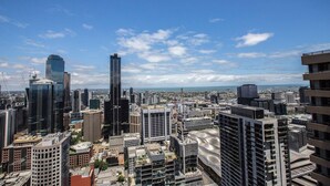 A cityscape with modern high-rise buildings, a clear sky, and a distant view of the coastline. - Cozy APT Seaview Next to Southern Cross/pool/gym (Melbourne)