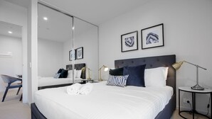 A modern hotel room with a large bed, a desk, and a chair. - Designer 2BR With Carpark Monash Uni@caulfield (Caulfield North)