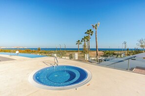 Une piscine offrant une vue dégagée sur l’océan, avec des palmiers en arrière-plan.
