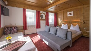 Een knus ingerichte kamer met een slaapbank, een bed en een televisie.