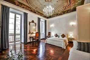 Um quarto amplo com uma cama grande, uma escrivaninha e uma cadeira.