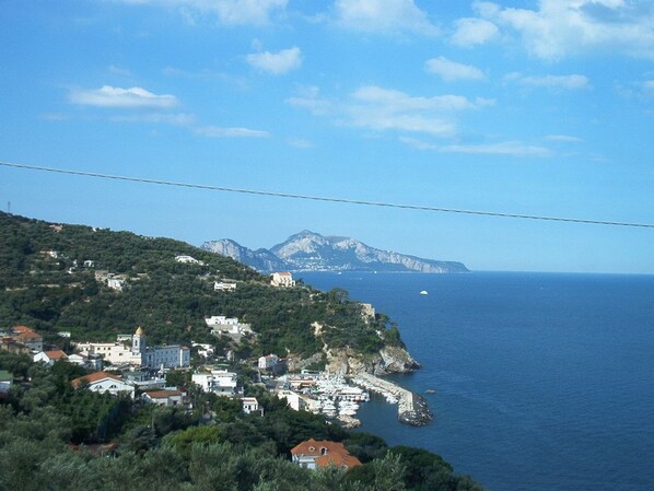 Un borgo costiero con edifici su una collina che si affaccia sul mare.